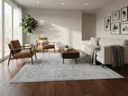 7' x 7' Square Ivory & Light Gray Distressed Textured Modern Washable Area Rug styled in a minimalist living room with a cream sofa, brown leather chairs, and wooden coffee table.