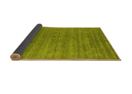 7' x 9' Abstract Green Olive Contemporary Area Rug rolled corner view highlighting the flexible backing and neatly finished edges.