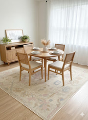 7' x 9' Ivory Pastel Multi Color Tribal Medallion Area Rug placed / styled in a dining room under a round wood dining table with four chairs and light airy curtains.