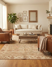 7' x 9' Rectangular Beige Rust Distressed Floral Vintage Traditional Washable Area Rug styled in a living room with a cream sofa and wooden coffee table.