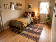 7' x 9' Rectangular Black Mustard Gold Rust Orange Plaid Geometric Modern Area Rug styled in a bedroom with a wooden bed frame and olive green bedding.