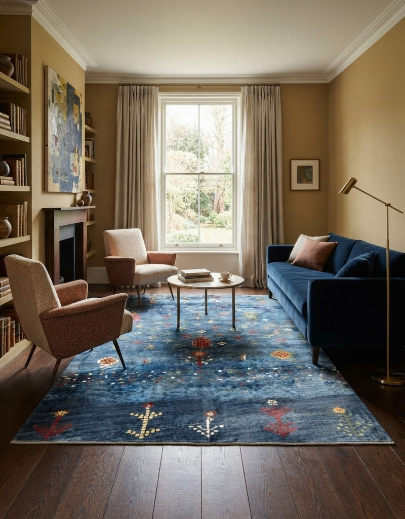 7' x 9' Rectangular Blue Multicolor Tribal Geometric Southwestern Area Rug styled in a living room with a blue sofa, beige armchairs, and round coffee table.