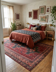 7' x 9' Rectangular Burgundy Charcoal Geometric Tribal Southwestern Area Rug placed in a bedroom with rust-colored bedding, wooden nightstands, and brass table lamps.
