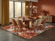 7' x 9' Rectangular Burnt Orange Golden Yellow Autumn Tree Botanical Modern Area Rug styled in a dining room with a round wooden dining table and beige upholstered chairs.