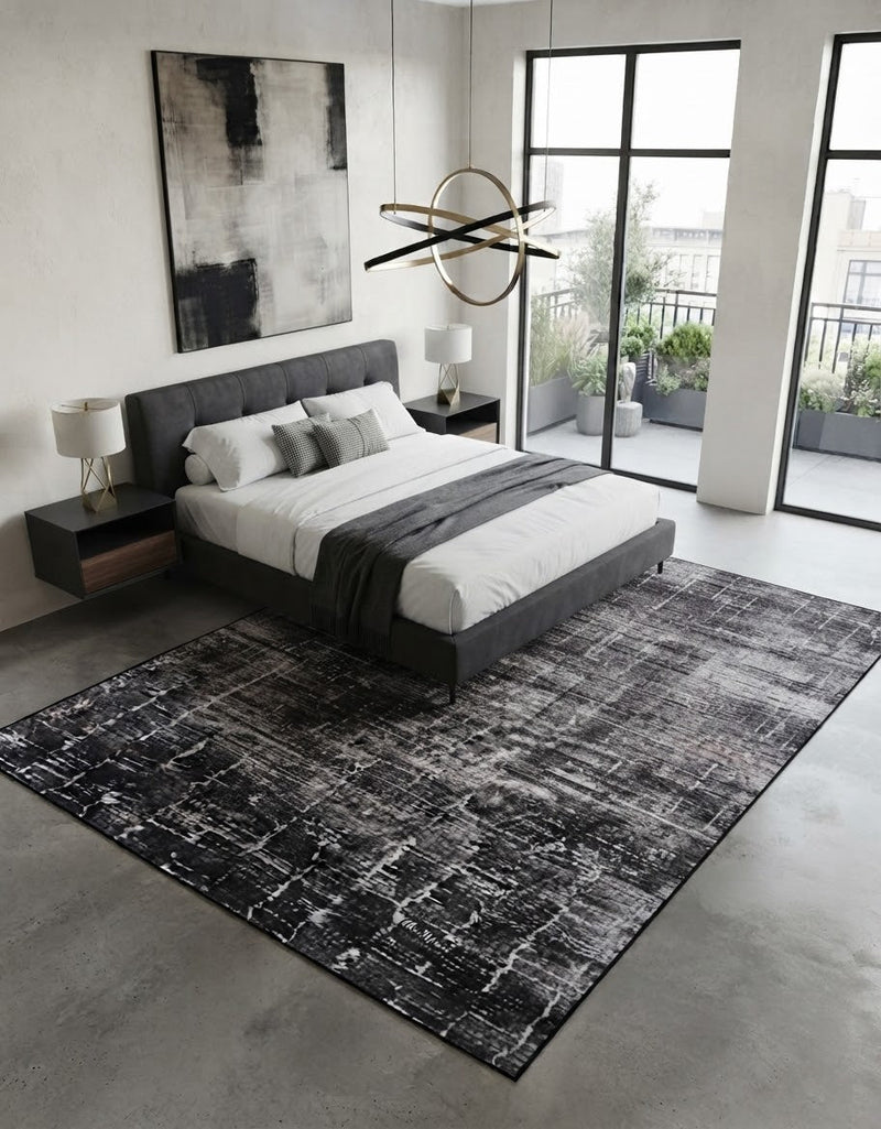 7' x 9' Rectangular Charcoal Gray Ivory Distressed Abstract Modern Washable Area Rug placed in a bedroom with a gray upholstered bed and white bedding.