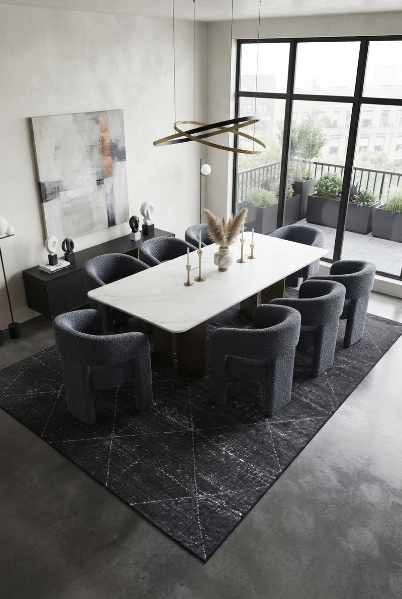 7' x 9' Rectangular Charcoal Gray Ivory Distressed Diamond Geometric Modern Washable Area Rug styled in a dining room with a white dining table and dark gray upholstered chairs.