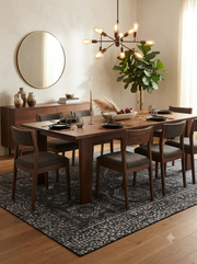 7' x 9' Rectangular Charcoal Gray Silver Distressed Geometric Medallion Traditional Washable Area Rug styled in a dining room with a wooden dining table and gray upholstered chairs.