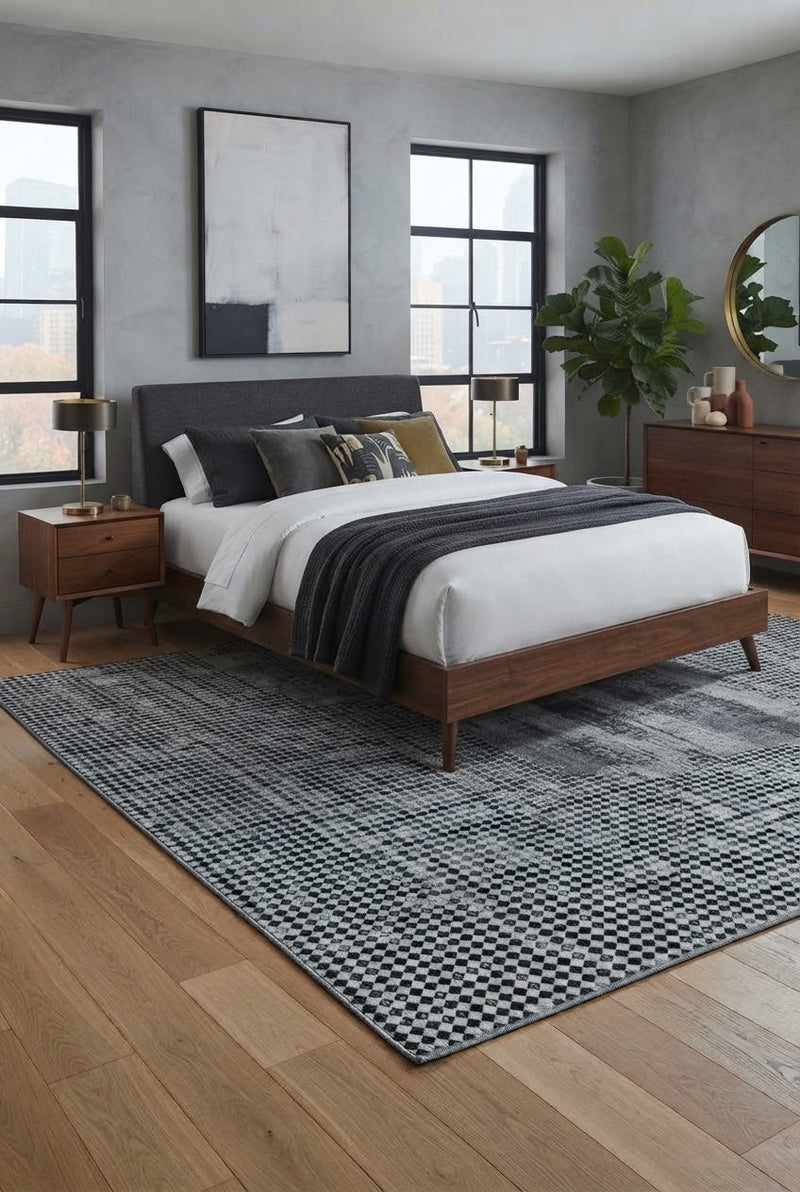 7' x 9' Rectangular Ivory Black Dotted Diamond Geometric Modern Washable Area Rug placed in a bedroom with a gray upholstered bed, white bedding, and wooden nightstands.