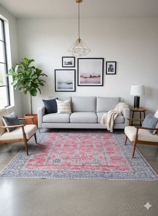 7' x 9' Rectangular Pink & Blue Gray Ivory Distressed Traditional Area Rug placed / styled in a modern living room centered under a light gray sofa with mid-century accent chairs and wall art.