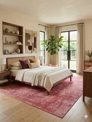 7' x 9' Rectangular Pink & Rose Distressed Oriental Vintage Area Rug placed in a bedroom with a wooden bed and cream bedding.