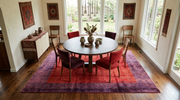 7' x 9' Rectangular Red & Purple Solid Border Contemporary Area Rug styled under a round dining table in a bright dining room.