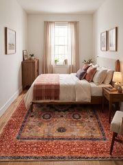 7' x 9' Rectangular Terracotta Beige & Navy Blue Patchwork Medallion Vintage Traditional Area Rug placed beneath a wooden bed with white bedding and a pink throw blanket.