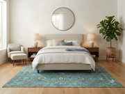 7' x 9' Rectangular Turquoise Blue Teal Distressed Floral Vintage Traditional Washable Area Rug placed in a bedroom with a beige upholstered bed and white bedding.