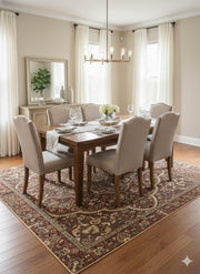 7' x 9' burgundy, brown, and ivory washable traditional medallion area rug styled beneath a wooden dining table with upholstered chairs in a bright classic dining room.