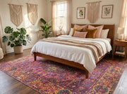7' x 9' raspberry pink multi-color washable bohemian medallion area rug styled in a warm boho bedroom with a natural wood bed frame, macramé wall hangings, and soft blush and mustard accent pillows.