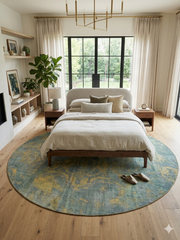 8' Round Blue & Gold Distressed Floral Traditional Washable Area Rug styled in a bedroom with a platform bed, neutral bedding, and wood flooring.