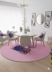 8' Round Pink Royal Blue Black White Geometric Abstract Modern Contemporary Area Rug styled in a dining room with a round white dining table and gray upholstered chairs.