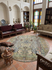 8' Round Sage Green Beige Multicolor Oriental Floral Traditional Washable Area Rug styled in a living room with carved wooden sofas and upholstered seating.