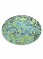 8' round blue teal abstract washable area rug featuring layered green and aqua tones with a non-slip backing.