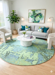 8' round blue teal abstract washable area rug styled in a contemporary living room with a light sofa, accent chairs, and a marble coffee table.