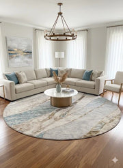 8' round ivory and beige abstract marble area rug styled in a bright living room with a neutral sectional sofa, round coffee table, and soft modern décor.