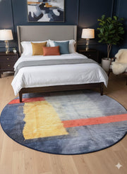 8' round navy blue multi-color abstract color block area rug styled under a bed in a modern bedroom with dark blue accent walls and contemporary décor.