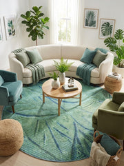 8' round sage green modern area rug with abstract leaf-like patterns styled in a cozy living room with a curved sofa, teal accent chair, and natural textures.