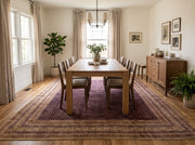 8' x 10' Rectangular Burgundy Gold Repeating Geometric Traditional Washable Area Rug styled in an elegant dining room with a rectangular wooden dining table, matching wooden chairs, modern chandelier, and natural greenery.