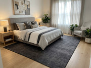 8' x 10' Rectangular Charcoal Black Gray Subtle Striped Modern Minimalist Washable Area Rug placed in a bedroom with a gray upholstered bed and white bedding.
