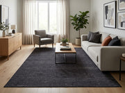 8' x 10' Rectangular Charcoal Black Gray Subtle Striped Modern Minimalist Washable Area Rug styled in a living room with a beige sofa and wooden coffee table.