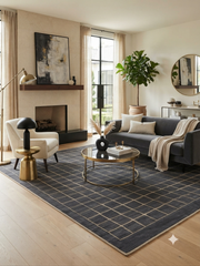 8' x 10' Rectangular Charcoal Gray Beige Grid Geometric Modern Washable Area Rug styled in a contemporary living room with a charcoal gray sofa, cream accent chair, round glass coffee table, gold accents, and large windows.