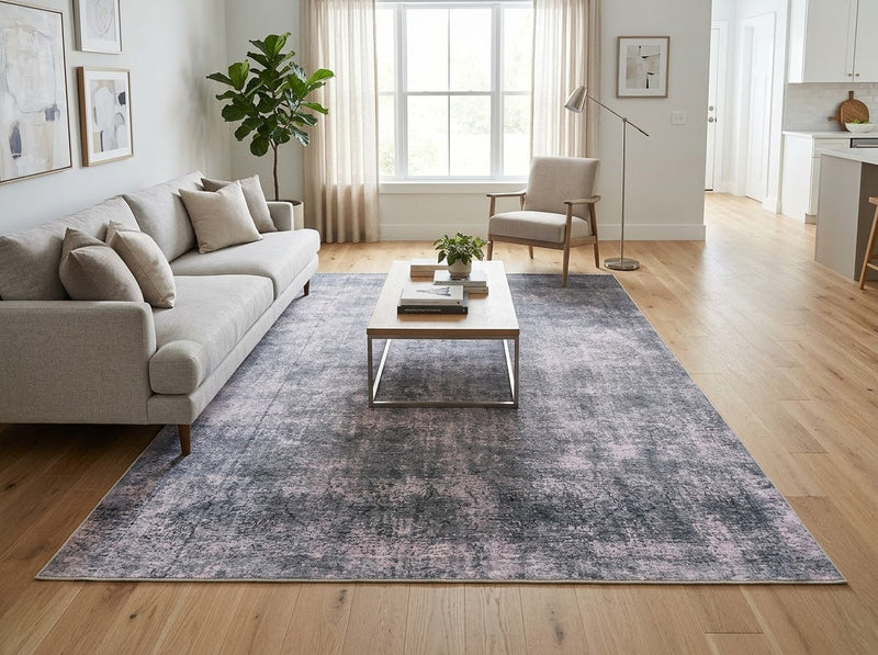 8' x 10' Rectangular Charcoal Gray Light Gray Distressed Abstract Modern Washable Area Rug styled in a living room with a beige sofa and wooden coffee table.