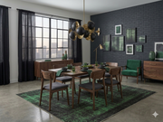 8' x 10' Rectangular Charcoal Green Distressed Abstract Modern Washable Area Rug placed in a contemporary dining room with a wooden dining table, gray upholstered chairs, green accent chair, and black and gold chandelier.