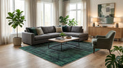8' x 10' Rectangular Emerald Green Charcoal Distressed Abstract Modern Washable Area Rug styled in a living room with a gray sectional sofa and wooden coffee table.