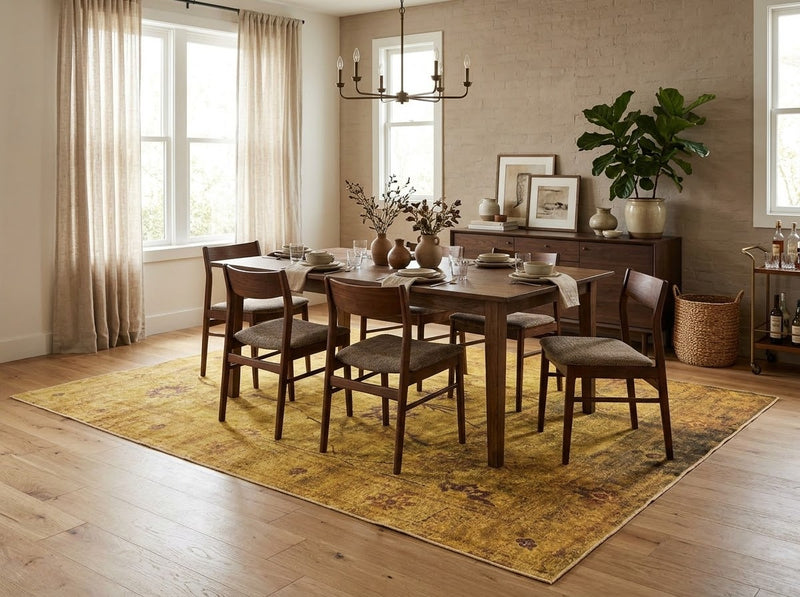8' x 10' Rectangular Mustard Gold Brown Distressed Floral Vintage Traditional Area Rug styled in a dining room with a wooden table and chairs.