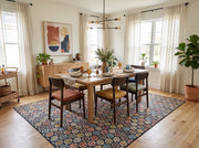 8' x 10' Rectangular Navy & Multicolor Repeating Geometric Modern Area Rug styled in a dining room beneath a wooden dining table and colorful upholstered chairs.