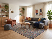 8' x 10' Rectangular Navy & Multicolor Repeating Geometric Modern Area Rug styled in a living room with a gray sectional sofa and round wooden coffee table.