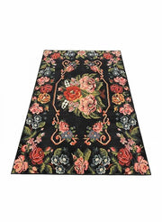 8' x 10' black multi-color floral vintage-inspired area rug featuring large botanical patterns with pink, coral, green, and blue accents on a dark background.