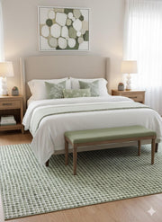 8' x 10' sage green and cream geometric washable area rug placed under a bed in a bright bedroom with neutral décor and soft green accents.