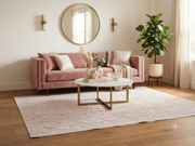 8' x 12' Rectangular Blush Pink Ivory Embossed Ornate Geometric Modern Washable Area Rug styled in a cozy living room with a pink sofa, round marble coffee table, and wooden furniture.