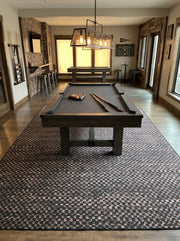 8' x 12' Rectangular Charcoal Black & Taupe Checkered Geometric Modern Washable Area Rug styled in a game room beneath a black pool table and industrial pendant lighting.