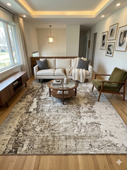 8' x 12' Rectangular Olive Green & Cream Distressed Abstract Modern Area Rug placed in a living room with a sofa, accent chair, and round coffee table.