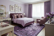 8' x 12' Rectangular Purple Lavender Floral Botanical Mosaic Modern Washable Area Rug placed in a cozy bedroom with a purple upholstered bed, lavender bedding, matching accent chair, floral artwork, and soft curtains.