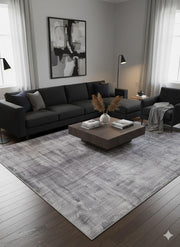 8' x 12' gray and ivory distressed abstract area rug styled in a modern living room with a black sectional sofa, minimalist décor, and a dark wood coffee table.
