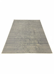 8' x 12' gray distressed solid washable area rug featuring soft beige undertones and a non-slip backing.