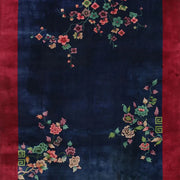 8' x 12' navy blue oriental area rug featuring a red border and delicate floral patterns in green, pink, and gold tones.