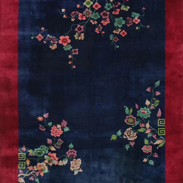8' x 12' navy blue oriental area rug featuring a red border and delicate floral patterns in green, pink, and gold tones.