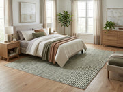 8' x 8' Square Ivory & Sage Green Repeating Geometric Modern Washable Area Rug placed in a bedroom beneath a cream upholstered bed with neutral bedding.