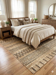8' x 8' square beige and brown rustic geometric washable area rug placed under a bed in a warm farmhouse-style bedroom with neutral bedding and wood furniture.