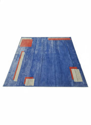 8' x 8' square blue area rug featuring a contemporary geometric design with rust and beige accent blocks and a subtle textured background.